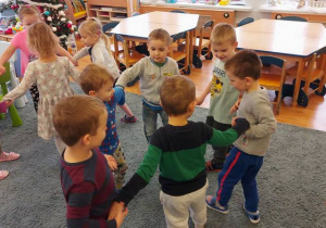Dzieci tańczą tworząc małe kółeczka.